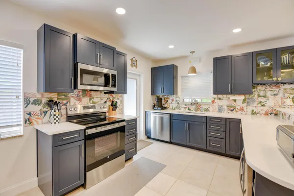 a kitchen with granite countertop cabinets stainless steel appliances and a counter top space