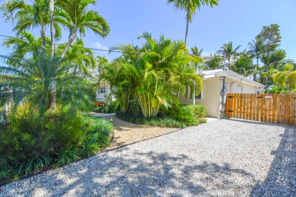 a kitchen with stainless steel appliances kitchen island granite countertop a stove top oven a sink dishwasher a dining table and chairs with wooden floor