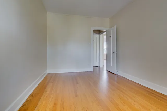 a view of a room with wooden floor and white walls