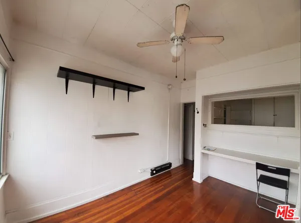 a hallway with wooden floor chandelier and a window