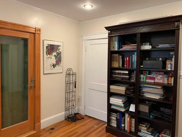 a view of a bedroom with workspace and wooden floor