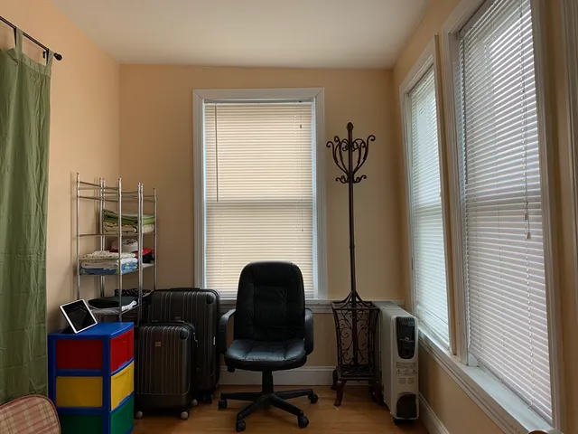 a view of a workspace with furniture and a window