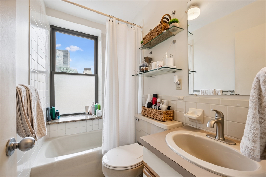 5 Grove Street, Unit 9 Boston, MA 02114 - Photo 12 of 24 a bathroom with a sink a toilet and shower