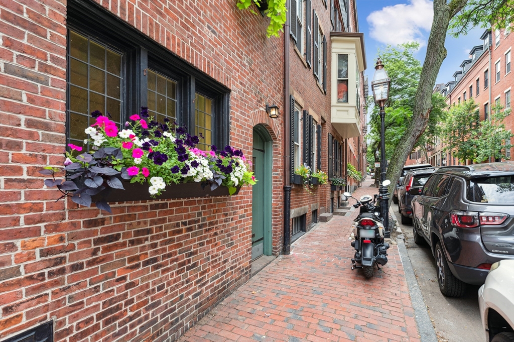 5 Grove Street, Unit 9 Boston, MA 02114 - Photo 24 of 24 a view of a house with a lot of flowers and many windows