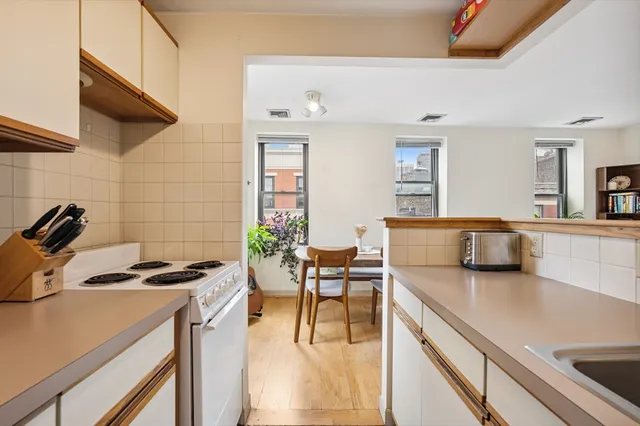 a kitchen with a table chairs stove and cabinets
