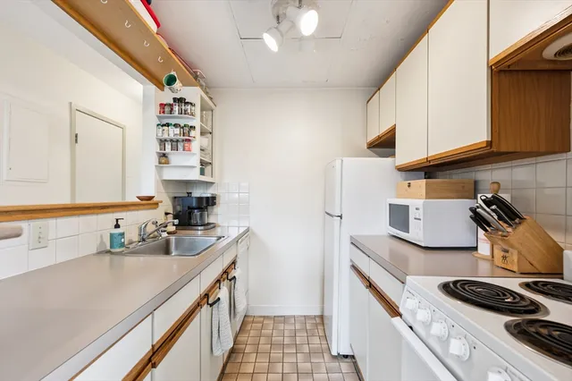 a kitchen with sink a stove and cabinets