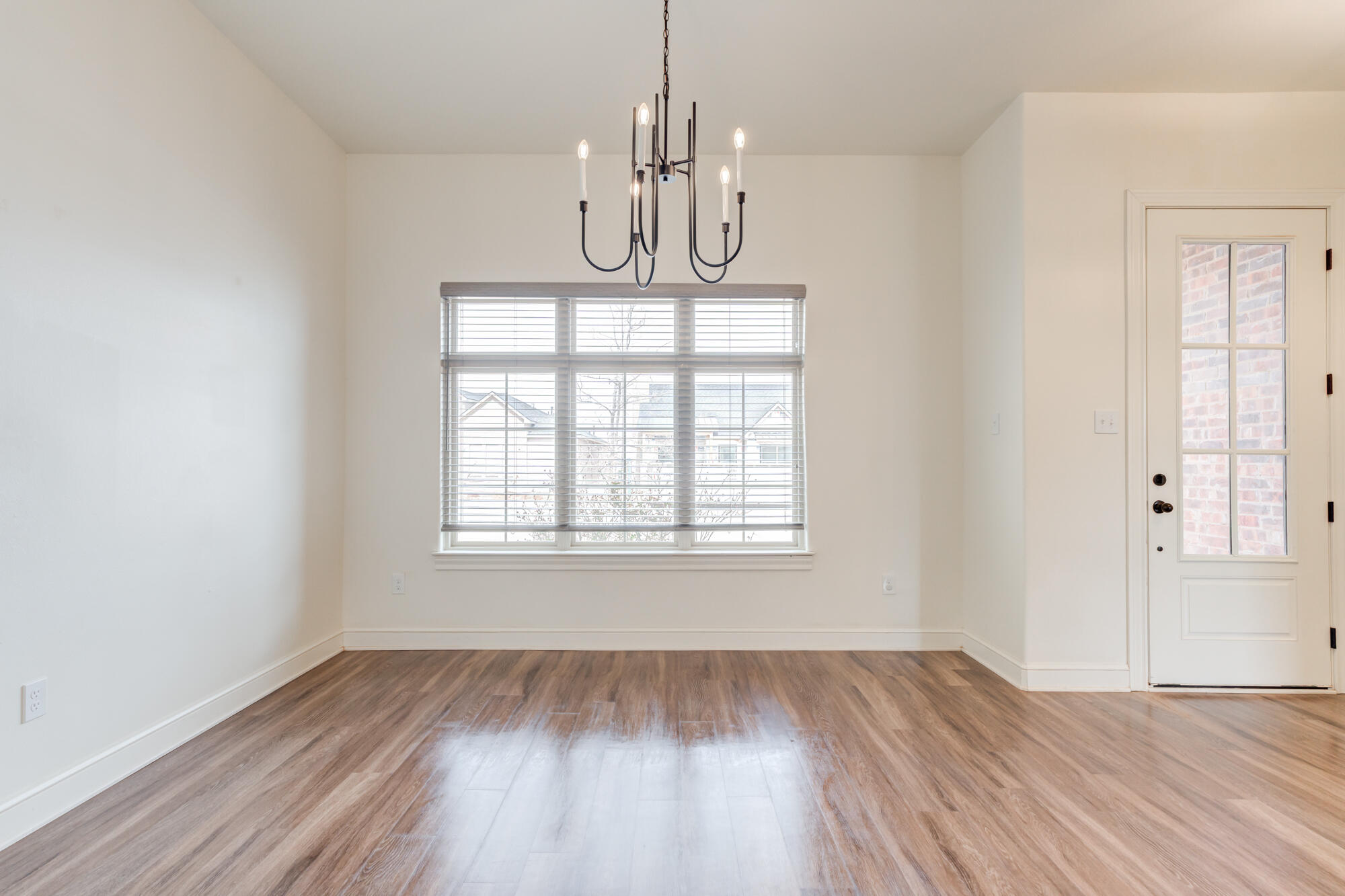 7603 52nd Street Lubbock, TX 79407 - Photo 11 of 46 an empty room with wooden floor exposed radiator and windows