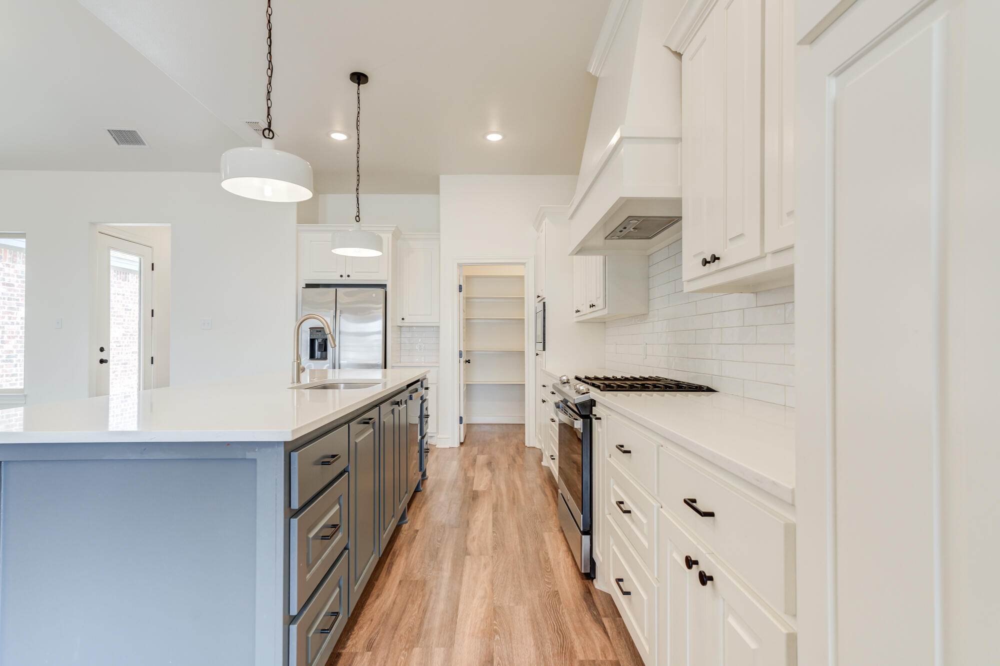 7603 52nd Street Lubbock, TX 79407 - Photo 12 of 46 a large kitchen with granite countertop a stove a sink dishwasher and a refrigerator with wooden floor
