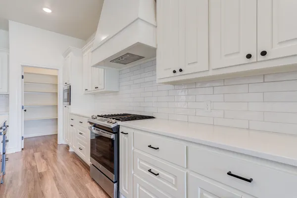 a kitchen with white cabinets and white appliances