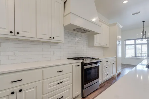 a kitchen with granite countertop white cabinets and white appliances