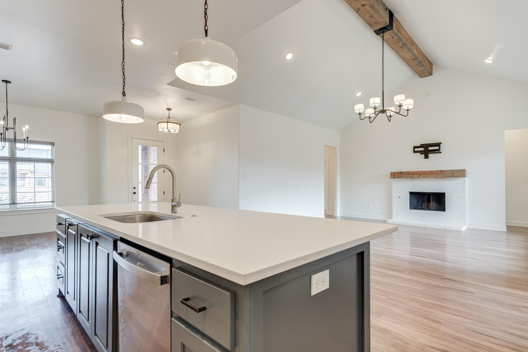 7603 52nd Street Lubbock, TX 79407 - Photo 20 of 46 a kitchen that has a sink a microwave oven a stove and a dining table with wooden floor