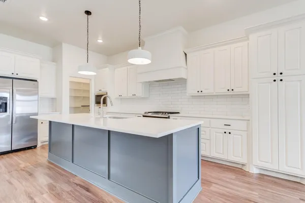 a kitchen with kitchen island a sink stainless steel appliances and cabinets