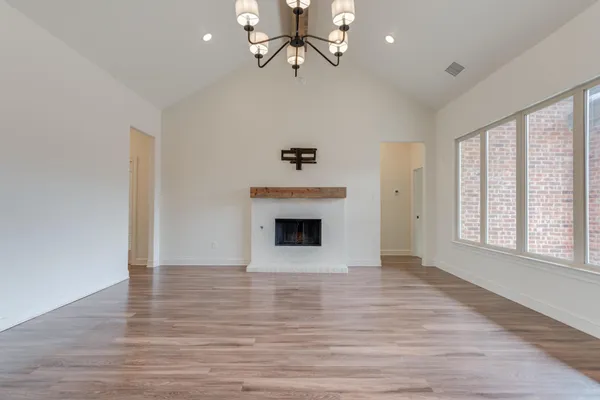 wooden floor fireplace and windows in an empty room