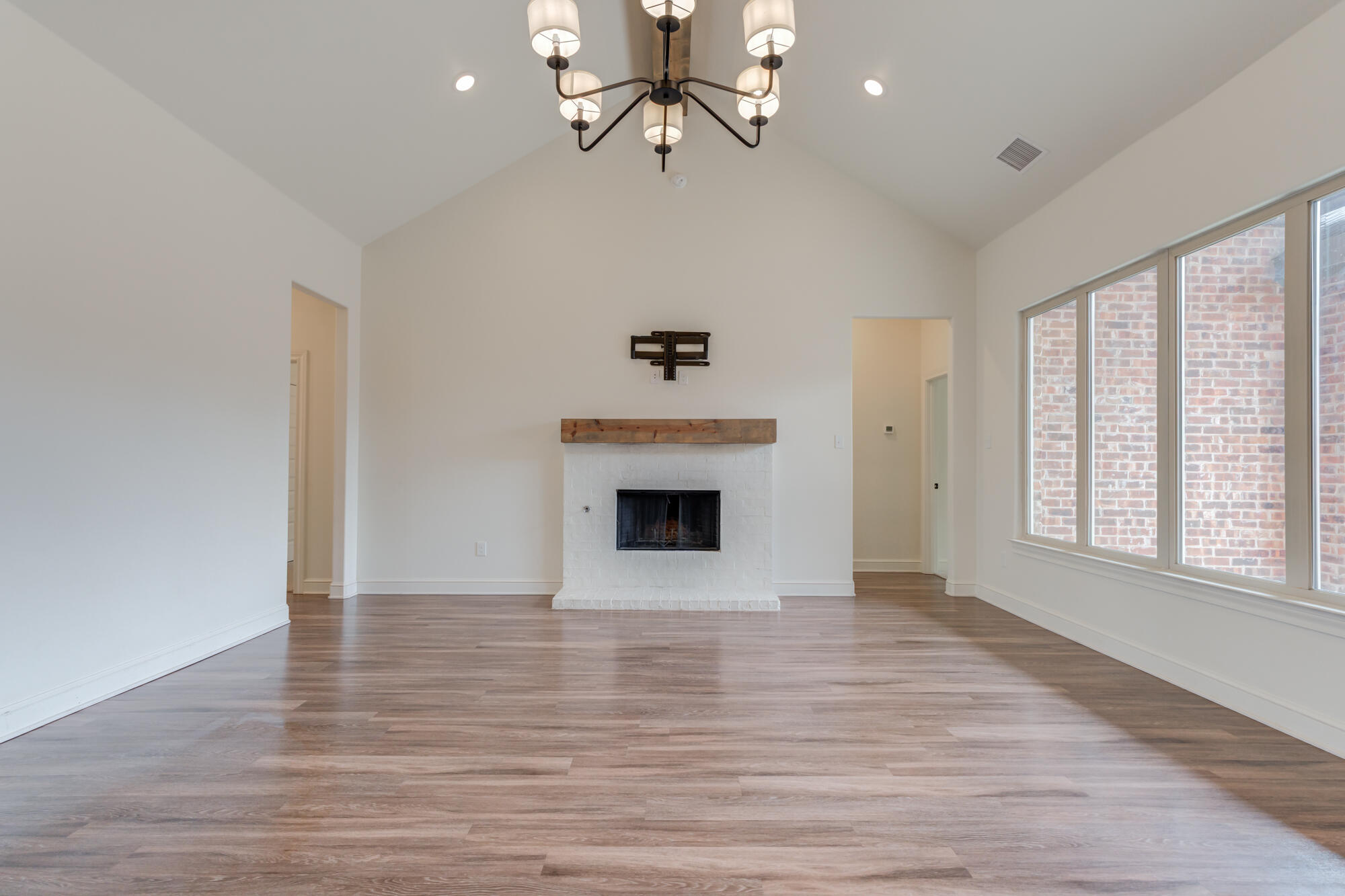 7603 52nd Street Lubbock, TX 79407 - Photo 21 of 46 wooden floor fireplace and windows in an empty room