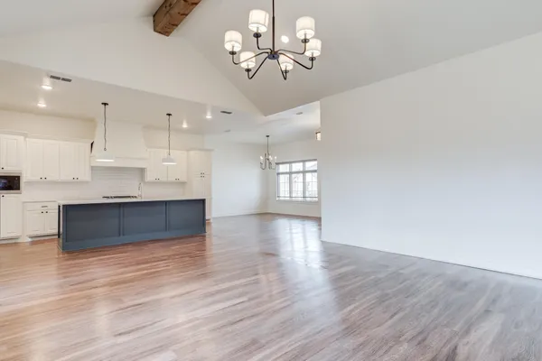 a view of a kitchen with a dishwasher a kitchen island hardwood floor and a sink
