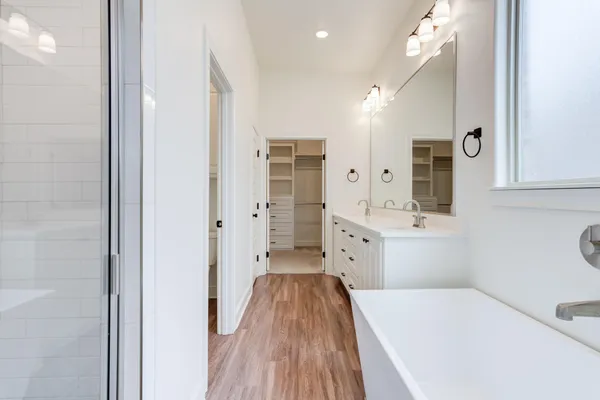 a bathroom with a sink a toilet a mirror and shower