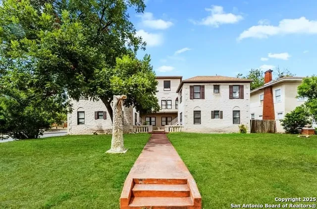 a front view of a house with a yard and trees