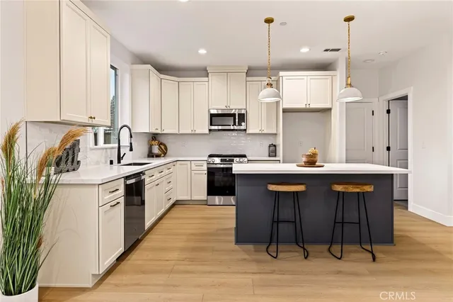a kitchen with granite countertop wooden floors and white cabinets