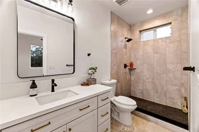 a bathroom with a sink a toilet and shower
