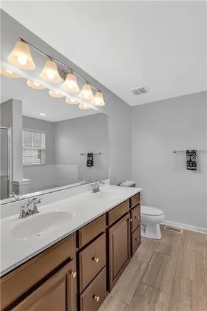 a bathroom with a sink a toilet and a mirror