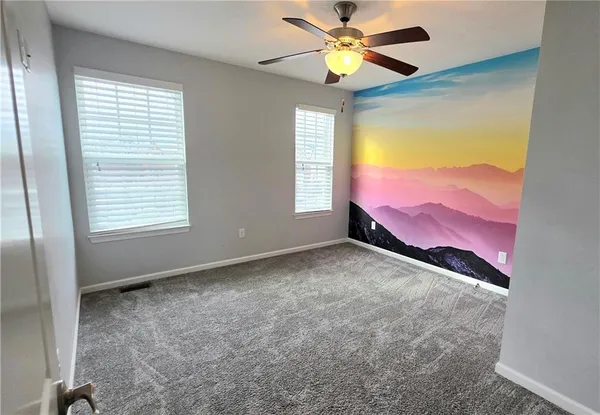a view of a bedroom with a fan and a window