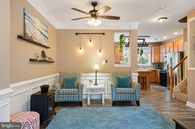 a kitchen with stainless steel appliances granite countertop a refrigerator a sink dishwasher a stove and a dining table with wooden floor