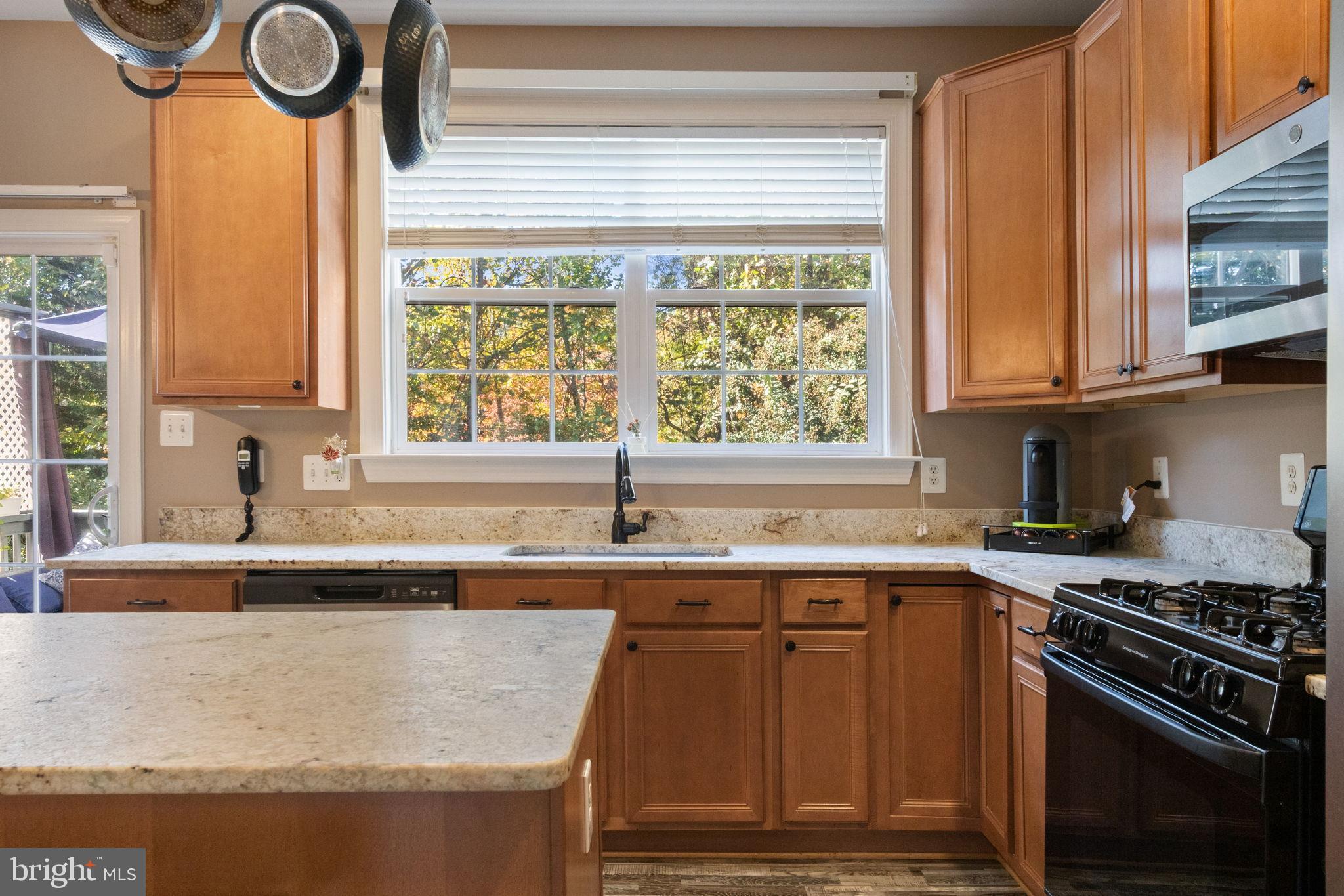 15636 Avocet Loop Woodbridge, VA 22191 - Photo 19 of 60 a kitchen with kitchen island granite countertop a sink a counter space appliances and a window