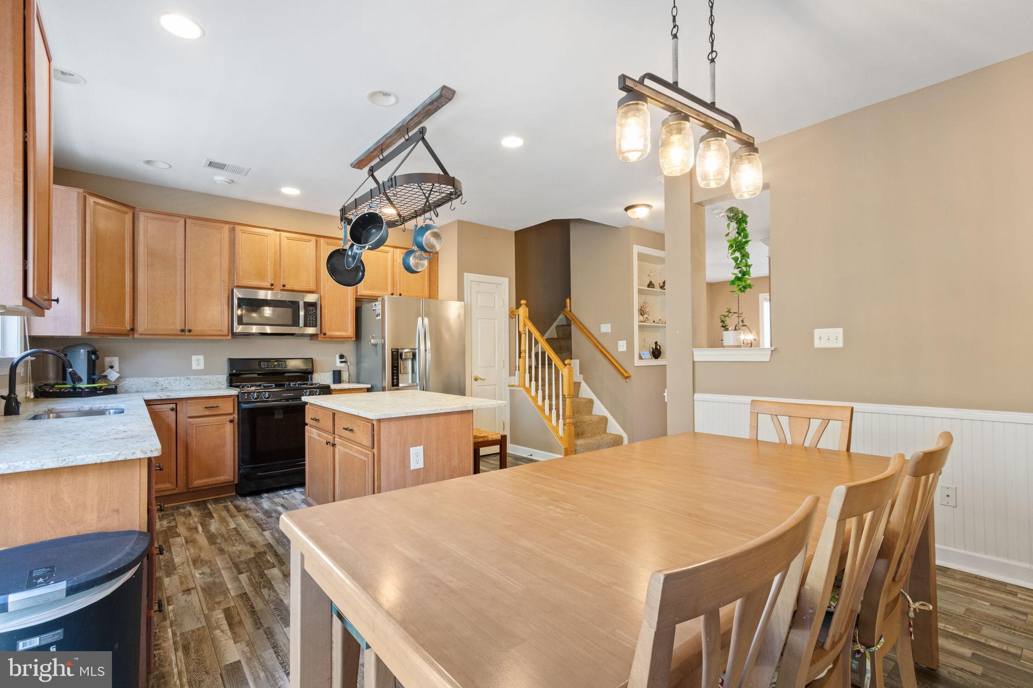 15636 Avocet Loop Woodbridge, VA 22191 - Photo 21 of 60 a kitchen with a table chairs sink microwave and stove
