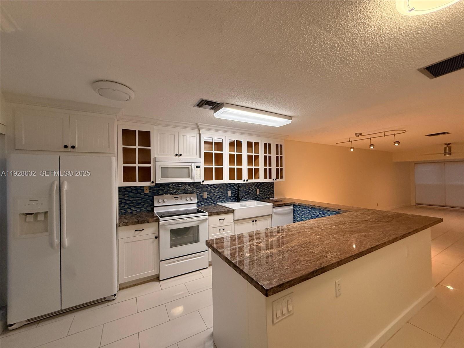a kitchen with kitchen island granite countertop a stove and a refrigerator