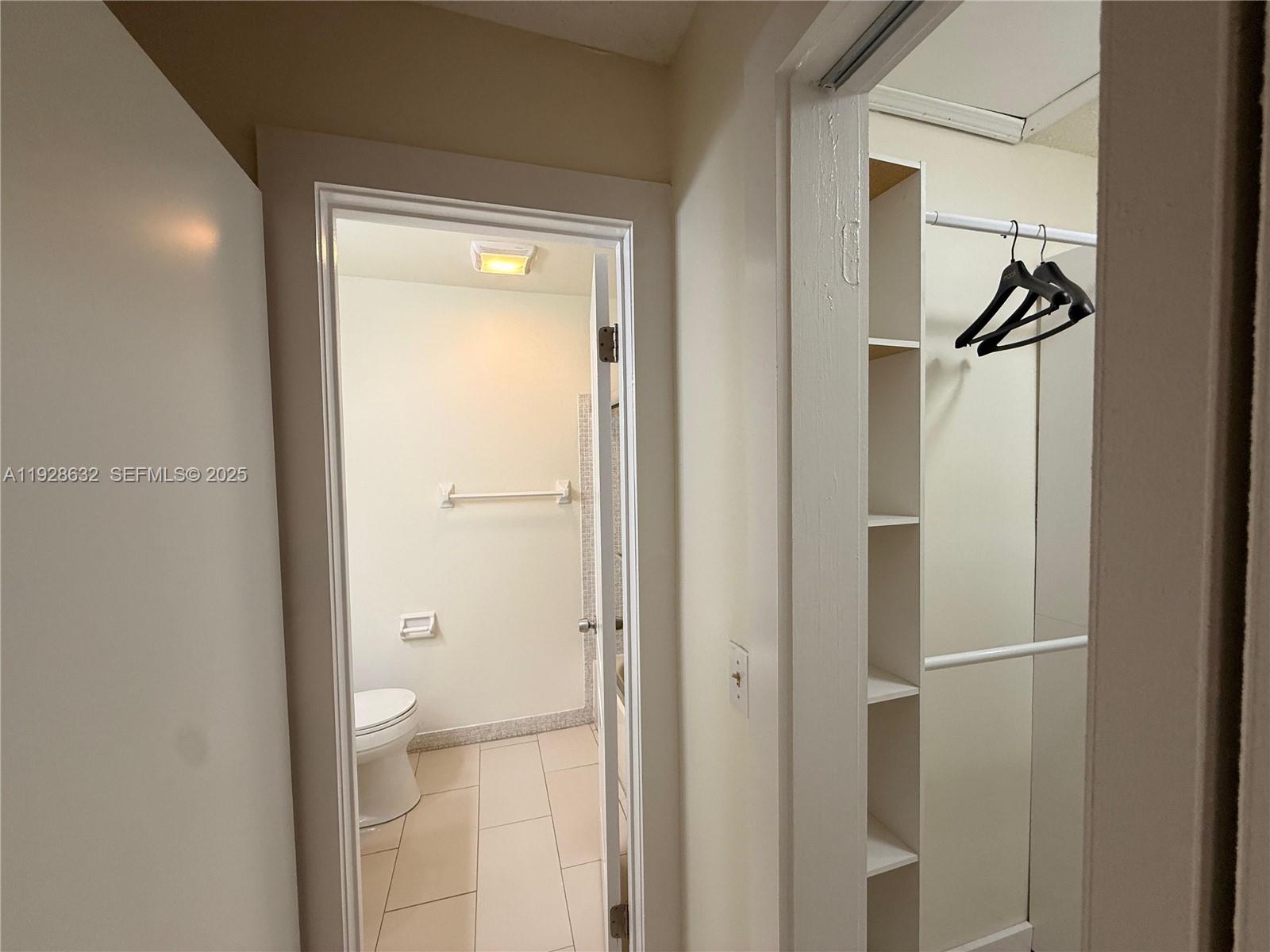 13741 Flora Place, Unit B Delray Beach, FL 33484 - Photo 21 of 50 a bathroom with a glass shower door and mirror