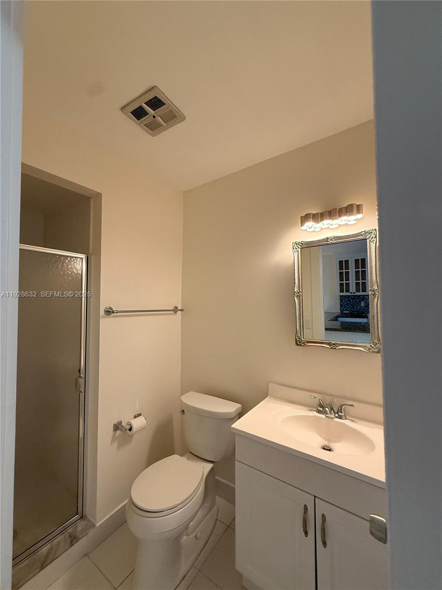 13741 Flora Place, Unit B Delray Beach, FL 33484 - Photo 27 of 50 a bathroom with a toilet sink and mirror