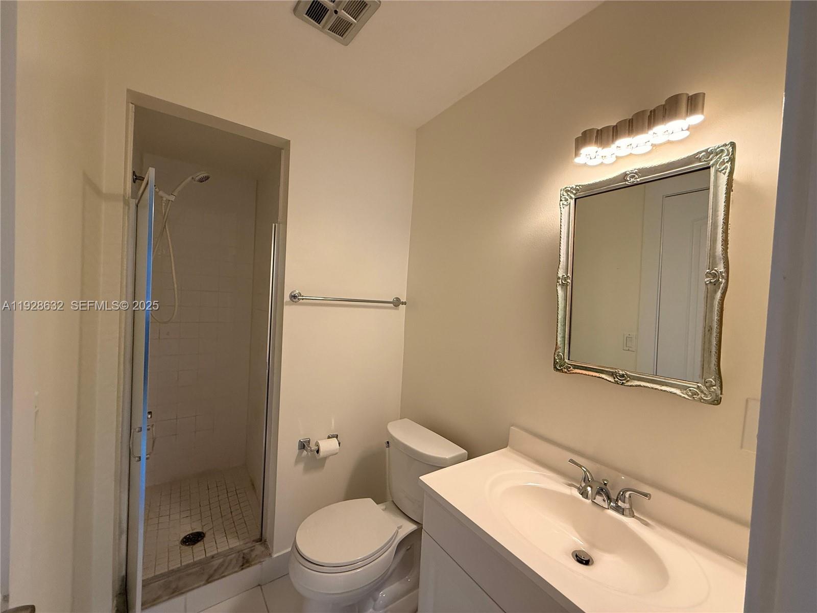 13741 Flora Place, Unit B Delray Beach, FL 33484 - Photo 38 of 50 a bathroom with a toilet a sink and mirror