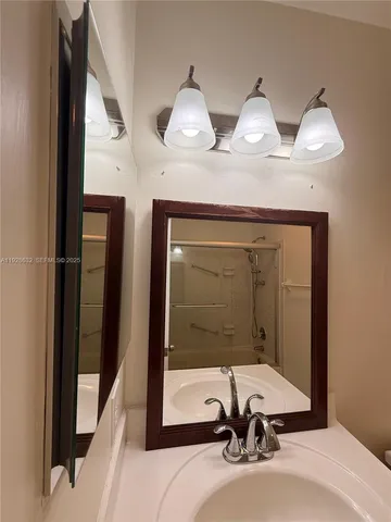 a bathroom with two sinks a mirror and a shower