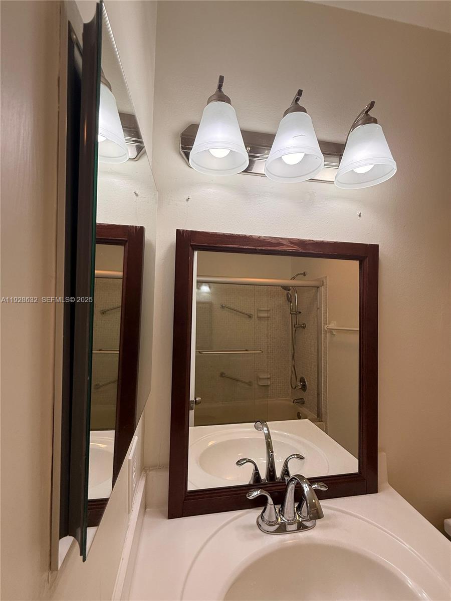 13741 Flora Place, Unit B Delray Beach, FL 33484 - Photo 39 of 50 a bathroom with two sinks a mirror and a shower