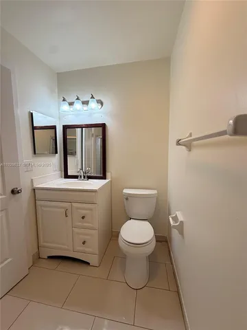 a bathroom with a toilet sink a mirror and vanity