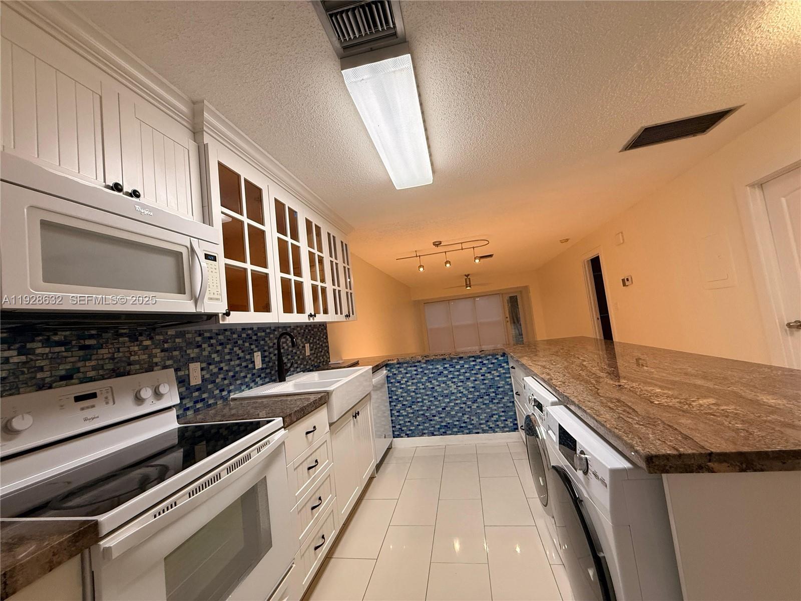 13741 Flora Place, Unit B Delray Beach, FL 33484 - Photo 4 of 50 a kitchen with stainless steel appliances granite countertop a stove and a sink