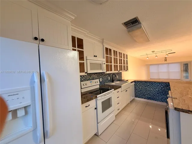 a kitchen with stainless steel appliances granite countertop a refrigerator and a stove