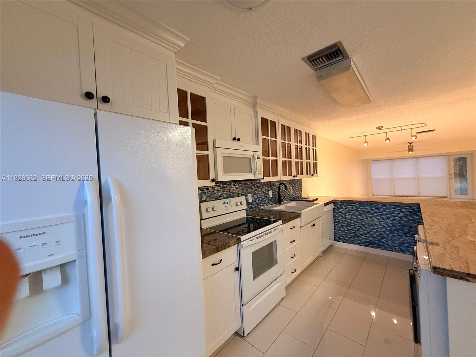 13741 Flora Place, Unit B Delray Beach, FL 33484 - Photo 6 of 50 a kitchen with stainless steel appliances granite countertop a refrigerator and a stove