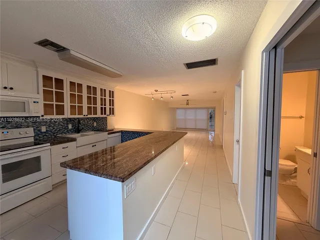 a kitchen with granite countertop a stove and a sink