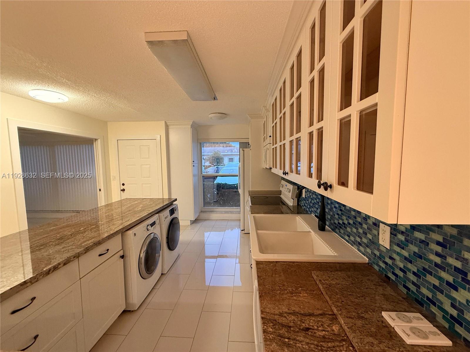 13741 Flora Place, Unit B Delray Beach, FL 33484 - Photo 8 of 50 a large white kitchen with granite countertop a sink and dishwasher a stove with wooden floor