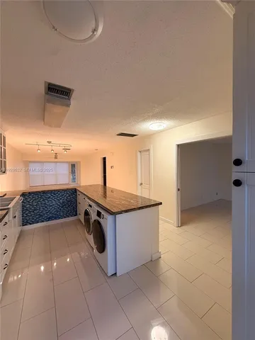a kitchen with stainless steel appliances kitchen island granite countertop a sink and cabinets