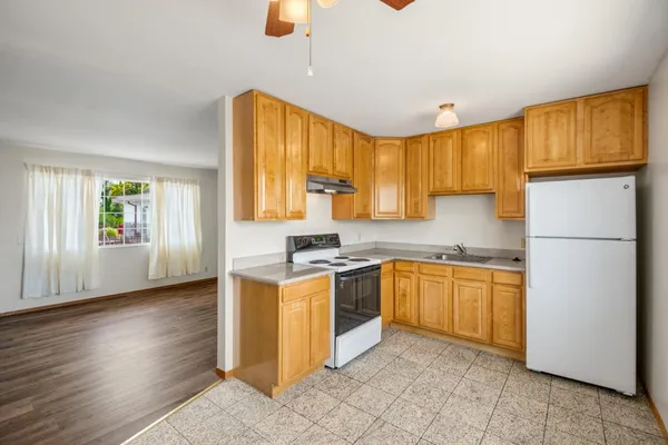 a kitchen with stainless steel appliances granite countertop a refrigerator a stove top oven a sink dishwasher and wooden cabinets