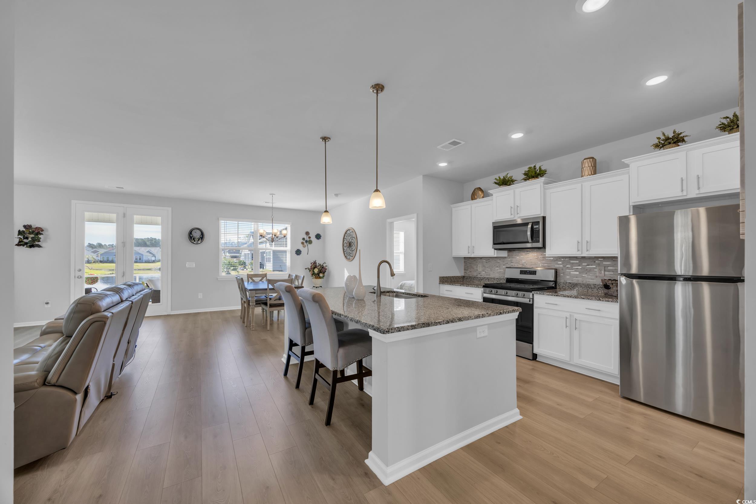 223 Juniata Loop Little River, SC 29566 - Photo 12 of 39 Kitchen featuring decorative backsplash, light woo