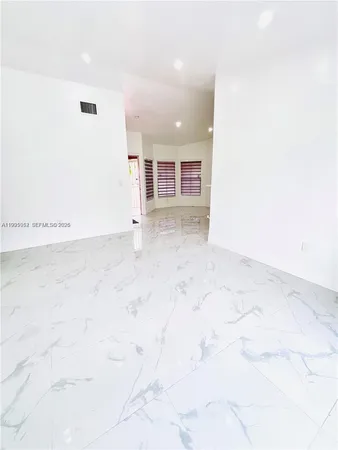 a view of a kitchen with kitchen island a sink wooden floor and entryway