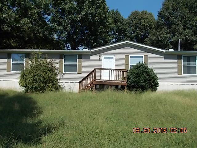 1973 South Commerce Road Watertown, TN 37184 - Photo 1 of 22 a white house that has a small yard and a large trees