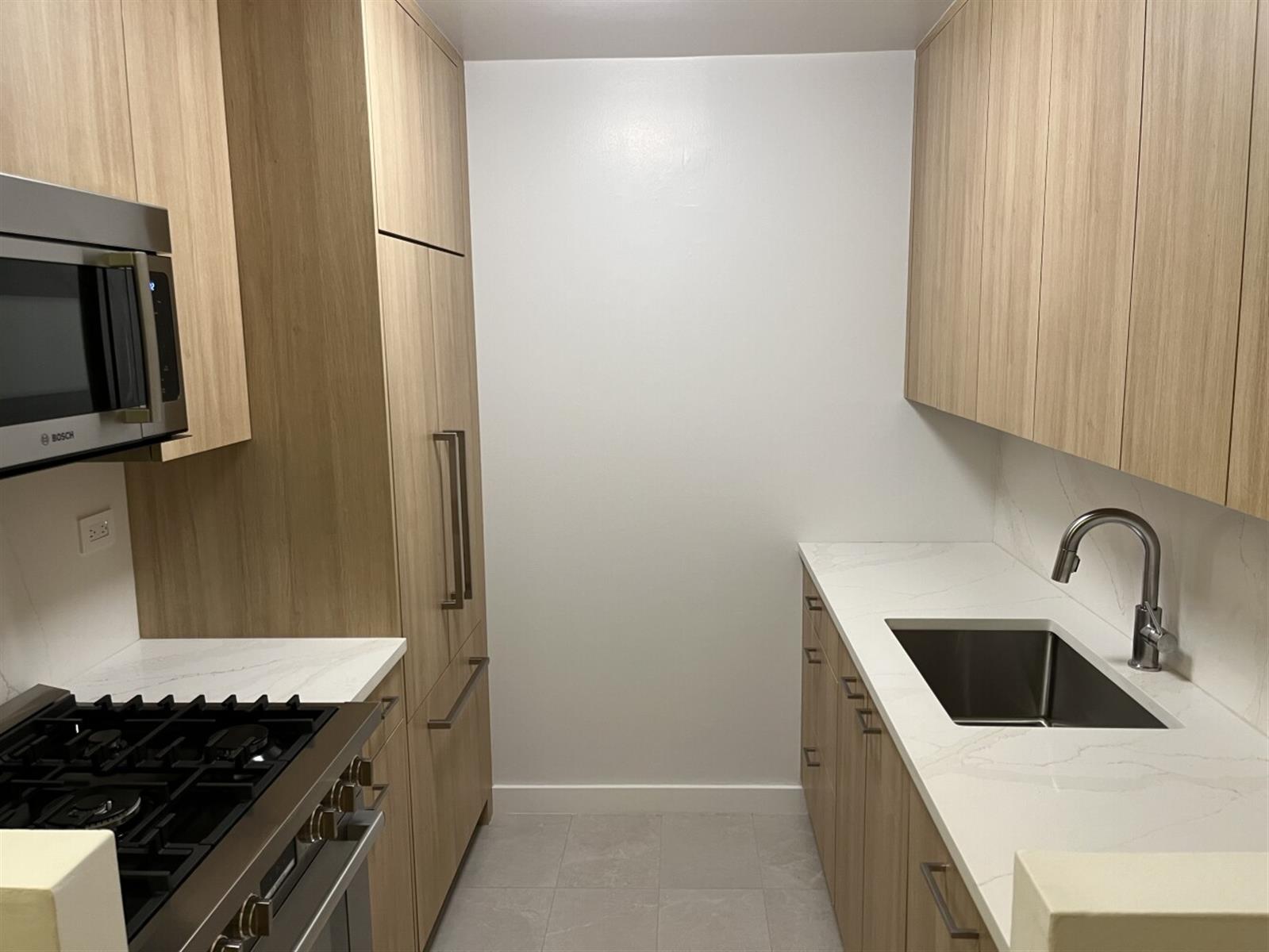 101 West 55th Street, Unit 701 Manhattan, NY 10019 - Photo 2 of 11 a kitchen with stainless steel appliances granite countertop a sink and a stove