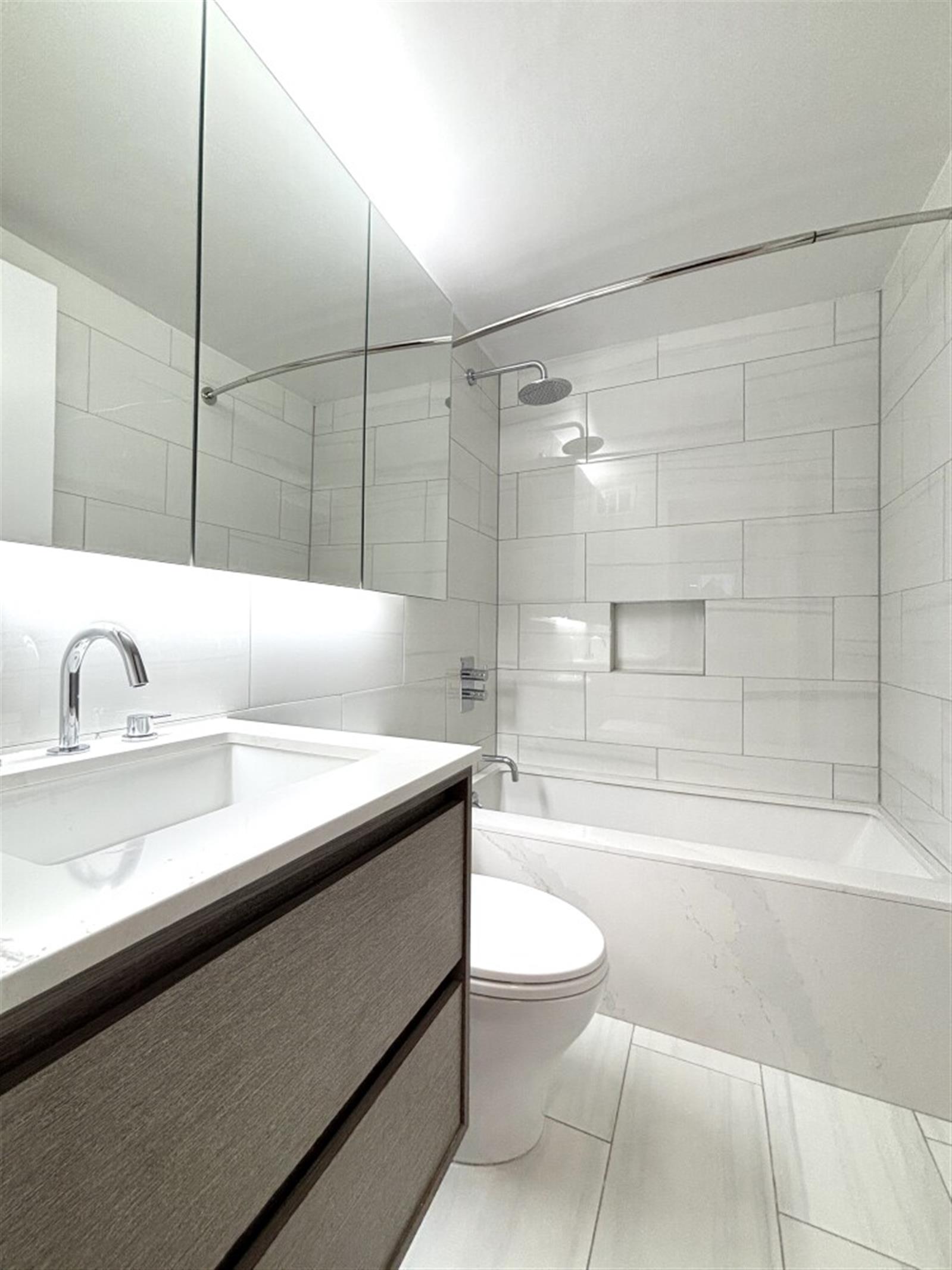 101 West 55th Street, Unit 701 Manhattan, NY 10019 - Photo 4 of 11 a bathroom with a sink a toilet and bathtub