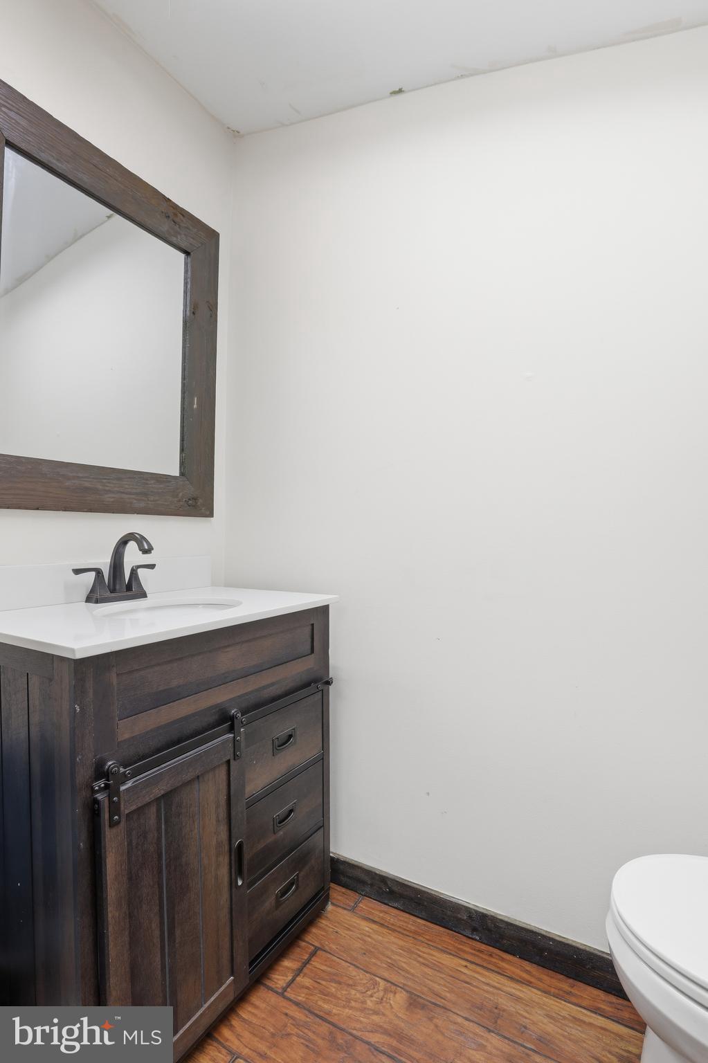 24815 Zoar Road Georgetown, DE 19947 - Photo 23 of 49 a bathroom with a sink vanity and a toilet