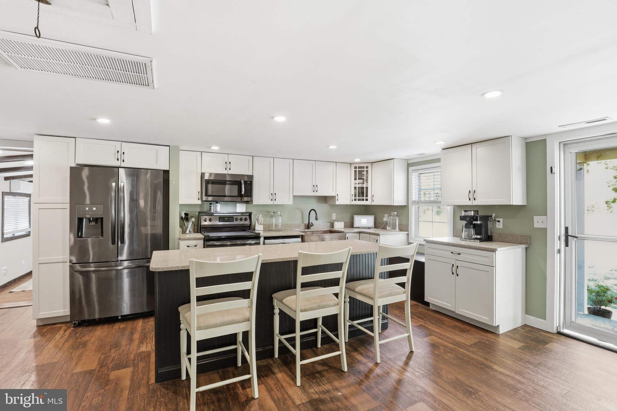 24815 Zoar Road Georgetown, DE 19947 - Photo 4 of 49 a kitchen with white cabinets and stainless steel appliances