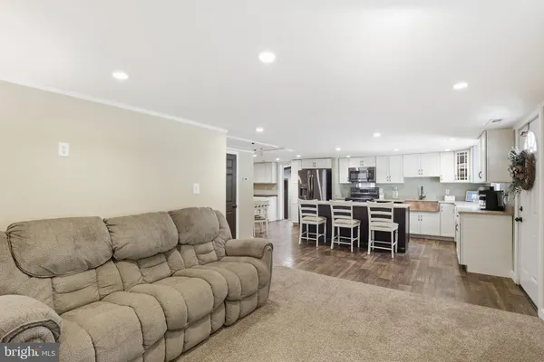 a living room with furniture and kitchen view